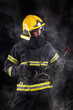 © blanke1973 - Firefighter fully equipped with helmet and ax in smoke, black background