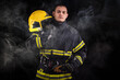 © blanke1973 - Firefighter fully equipped with helmet and ax in smoke, black background