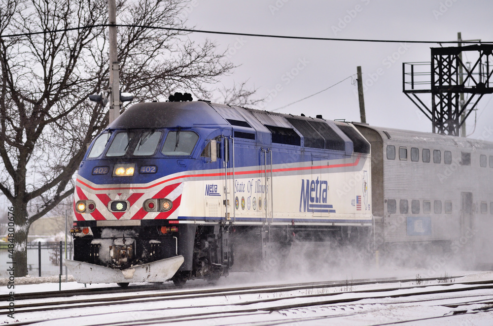 A Metra commuter train speeds through snow just prior to arriving at the Franklin Park, Illinois station with a load of commuters from Chicago.