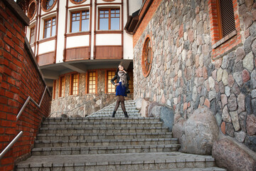 Wall Mural - young girl stands on the stairs near the old castle