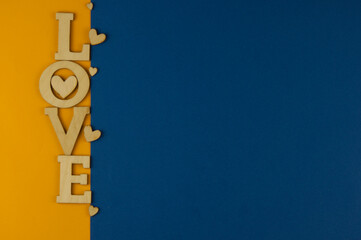 Wall Mural - Love word, small hearts on colorful paper background. Top view of Valentine's Day.