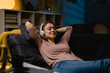 © cherryandbees - woman relaxing at home listening music on headphones
