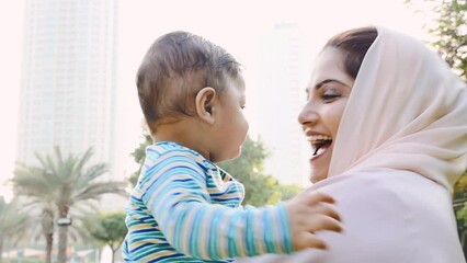 Wall Mural - Mother and little son spending time together at the park. Muslim family outdoor in Dubai. Lifestyle moments in the UAE