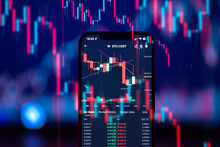 Cryptocurrency Market Is Going Down, Is Time To Sell, Red Candles. The Graph Evolution Of Bitcoin On A Laptop And Smartphone Display Showing The Prices Falling.