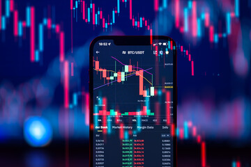 Cryptocurrency market is going down, is time to sell, red candles. The graph evolution of Bitcoin on a laptop and smartphone display showing the prices falling.