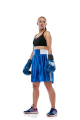 Wall Mural - Portrait of young beautiful girl, professional boxer in boxing shorts and gloves posing isolated on white studio background. Concept of sport, studying, competition