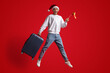 © Prostock-studio - Happy Male Traveller Wearing Santa Hat Jumping With Spanish Flag And Suitcase