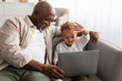 African American Grandpa And Grandson Video Calling Via Laptop Indoor