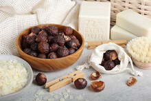 Soap Nuts Or Soap Berrys With Linen, Hard Soap Bars And Clothespins In The Environmentally Friendly House Close Up. Natural Laundry Detergent, Zero Waste And Eco Friendly.