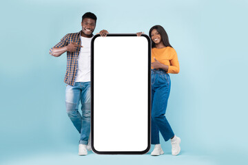 Wall Mural - Couple showing white empty smartphone screen leaning on display