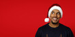 © Prostock-studio - Interested black man in Santa hat looking at copy space