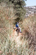 EIn Mann reitet auf einem schmalen Wanderweg durch die Natur auf der griechischen InselAmrogos