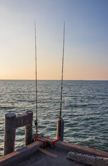 Sticker - A nice angler's place with his fishing rods right on the pier from the sea