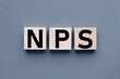 concept word NPS .Net Promoter Score. on wooden cubes text on wooden blocks. on a gray background.
