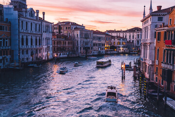 Motorboat taxi transport floating in Venecian gran Canal during evening time for romantic sightseeing excursion, scenery view on ancient architecture buildings and monument showplaces in Italy