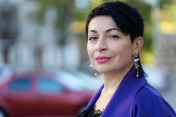 An elegant woman in a stylish outfit poses on a city street