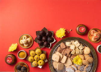 traditional indian sweets on red background flat lay