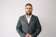 © MarijaBazarova - Handsome man with beard wearing business jacket and glasses looking to camera, serious profile pose with natural face standing on white background and posing in studio. Copy space