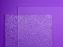 Embossed Glass On A Purple Background Top View. Two Samples Of Different Textured Glass. Glass Transparent Embossed Close-up.