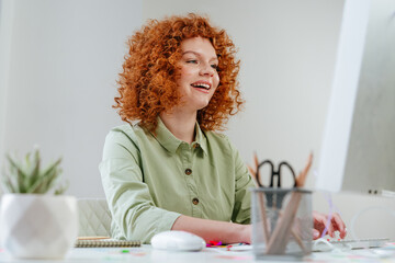 Young business woman with red curly hair working in the office