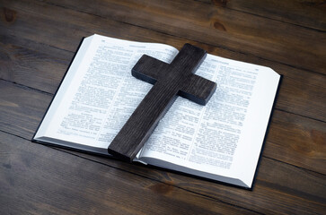 Wall Mural - Bible open. Cross, crucifixion of Jesus. Love concept. On a wooden table.