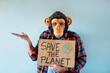 © karrastock - Man with monkey mask showing a sign that says SAVE THE PLANET.