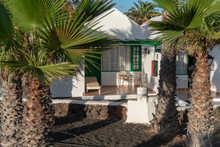 Entrada De Una Casa Típica De Lanzarote En Islas Canarias Con Una Fachada Blanca Rodeada Por Palmeras En Un Día De Verano Soleado