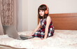 © gmstockstudio - Little girl using the laptop with earphones