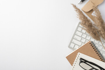 Top view photo of workspace keyboard planners glasses pen envelope letter and reed flowers on isolated white background with empty space