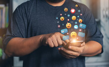Hands Holding And Typing To Communicate With Others Through Emoji Emotion. Online Social Communication,Social Media,emotion, Hearts. Chat Conversation On Mobile. Man Working Using Chatting Application