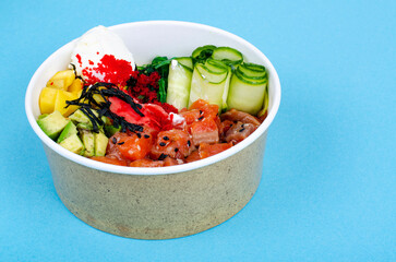 Wall Mural - Poke with sea food and vegetables on blue background. Studio Photo