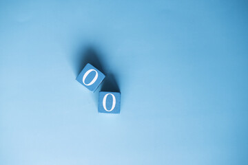 number zero on wooden block on blue background 