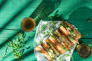 Wall Mural - Sandwich with chicken, cucumber and arugula on a green background