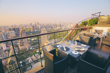 Sticker - Table setting on roof top restaurant with megapolis view, Bangkok Thailand.