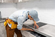 © Angelov - Master installs electric hob on kitchen cabinet.