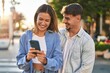 © Krakenimages.com - Young man and woman couple smiling confident using smartphone at street