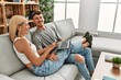© Krakenimages.com - Young caucasian couple smiling happy using laptop sitting on the sofa at home.