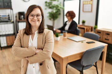 Canvas Print - Down syndrome girl working at inclusive teamwork. Group of two women working at the office