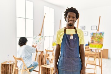 Canvas Print - African young man standing at art studio with a happy and cool smile on face. lucky person.