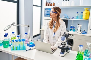 Sticker - Young blonde woman wearing scientist uniform using laptop at laboratory