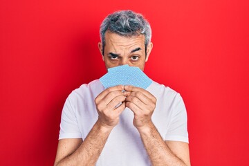 Canvas Print - Handsome middle age man with grey hair covering face with cards skeptic and nervous, frowning upset because of problem. negative person.