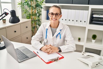 Poster - Young blonde woman wearing doctor uniform working at clinic