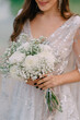 © MZaitsev - Close-up of bride's bouquet. Bride holds wedding bouquet of white chrysanthemums in her hands.