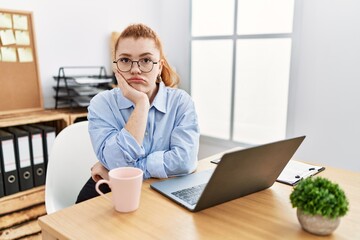 Sticker - Young redhead woman working at the office using computer laptop thinking looking tired and bored with depression problems with crossed arms.