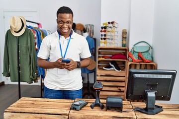 Young african man working as shop assistance using smartphone at retail shop