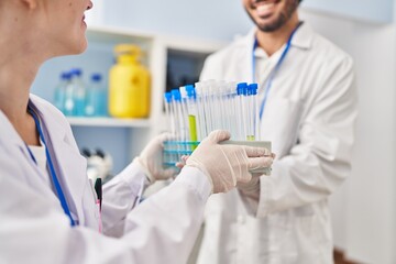 Sticker - Man and woman scientist partners holding test tubes at laboratory