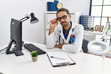 Wall Mural - Handsome hispanic man working as doctor at hospital clinic