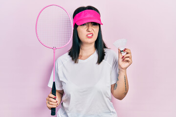 Sticker - Young hispanic woman holding badminton racket and shuttlecock clueless and confused expression. doubt concept.