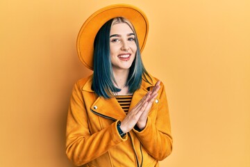 Sticker - Young modern girl wearing yellow hat and leather jacket clapping and applauding happy and joyful, smiling proud hands together