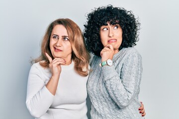 Sticker - Middle east mother and daughter wearing casual clothes thinking worried about a question, concerned and nervous with hand on chin